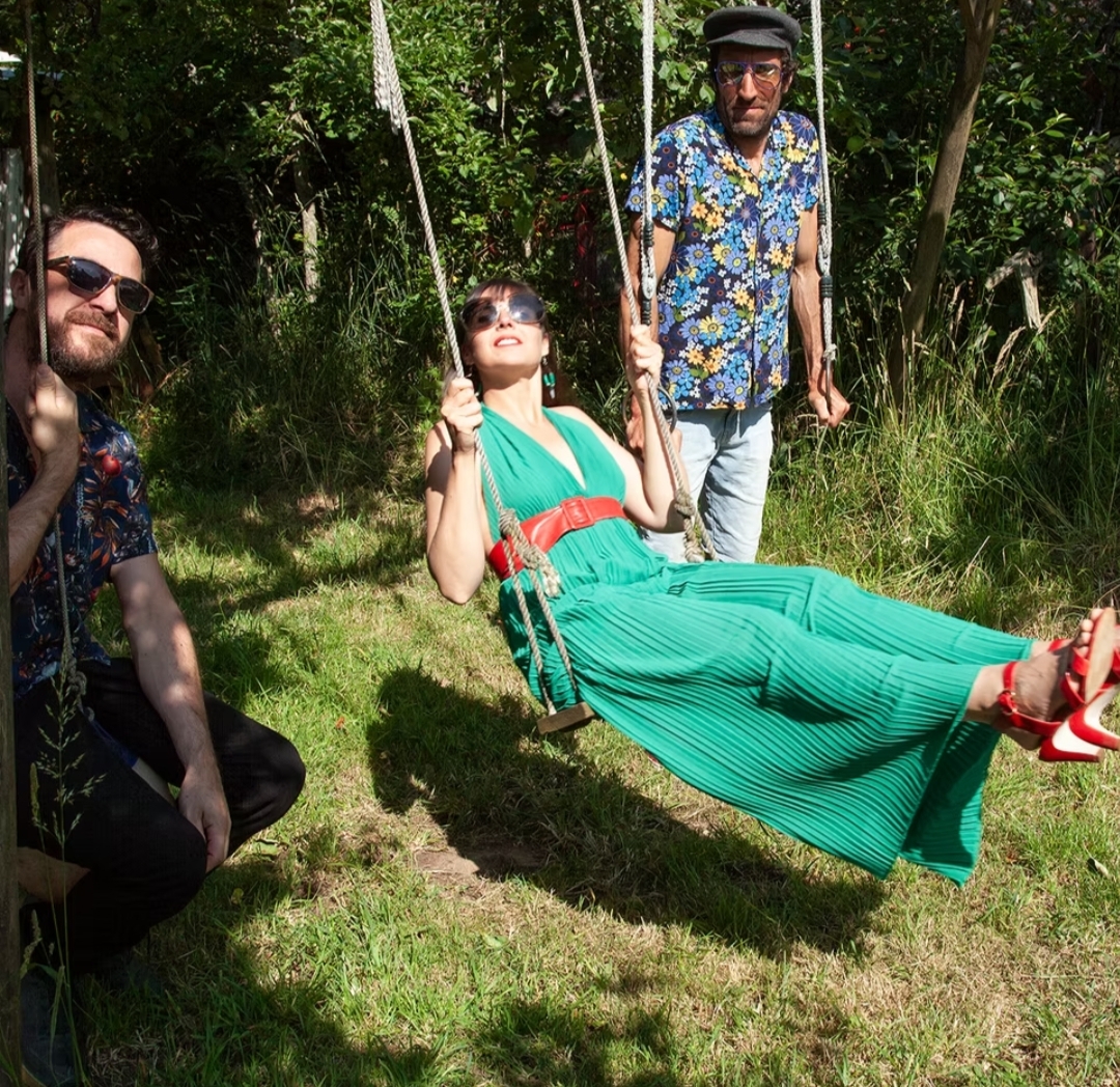 le trio ALOKO Ah Louco en photo à l'extérieur avec la chanteuse sur une balançoire